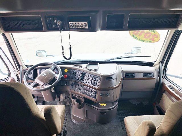 Interior of a 2018 Volvo VNL 670 truck cab showing steering wheel, dashboard with controls, center console, and two front seats.