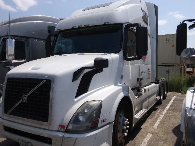 Volvo 670 sleeper cab truck in a parking lot showing front grille, headlights, and side mirrors.