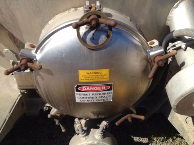 Vacuum tank dome showing warning labels and several brown pipes/outlets.