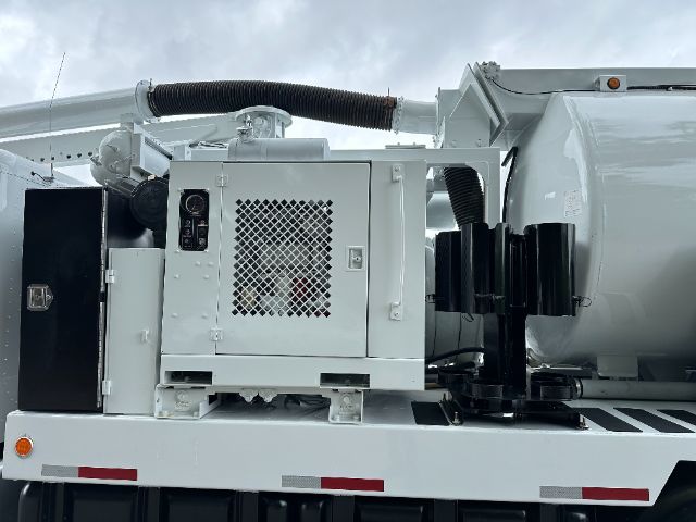 Vehicle engine bay area of a 2008 Peterbilt 340 vacuum truck showing a white generator box with a mesh vent and adjacent components.