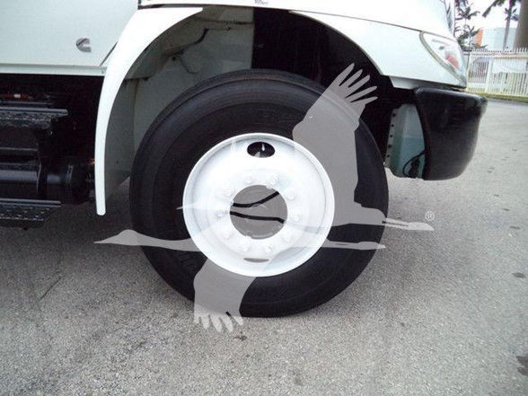 Front wheel of a 2019 International DURASTAR 4300 box truck showing front suspension and wheel with white steel rim.
