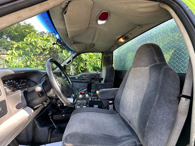 Interior of a 2001 Ford F550 fire truck showing driver seat, passenger seat, steering wheel, dashboard, and overhead console.