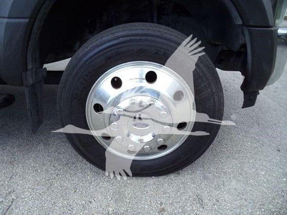 Ford F-450 wheel showing steel hubcap and tire on front left side.