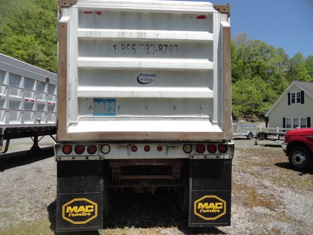 Rear view of a white 1998 USTS 32ft trailer with blue plate numbers and ‘Friends of Coal’ sticker; MAC Trailer mud flaps; residential area in background.
