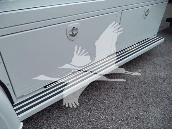 Side view of a white Kenworth truck lower side panel and steps with rubber edge trim; no legible text visible.