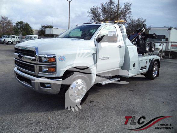 Front-left view of a white 2023 Chevrolet Silverado 6500HD tow truck with wheel-lift equipment and TLC Truck & Equipment watermark.