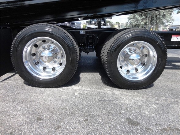 Dual rear wheels on a 2023 Kenworth W990 truck with polished chrome rims.