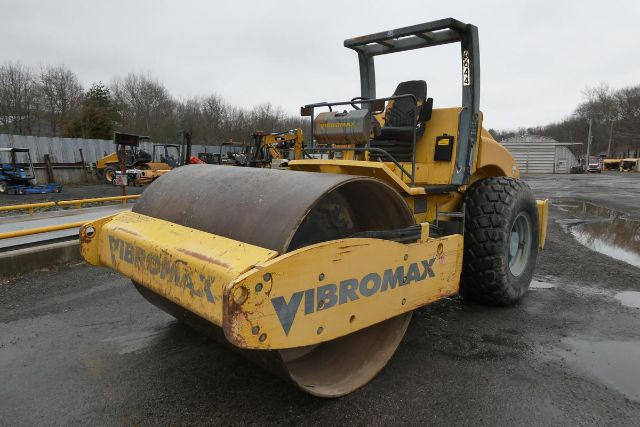 Vibromax VM106D roller with large front drum, operator seat, and yellow body showing Vibromax branding on the side.