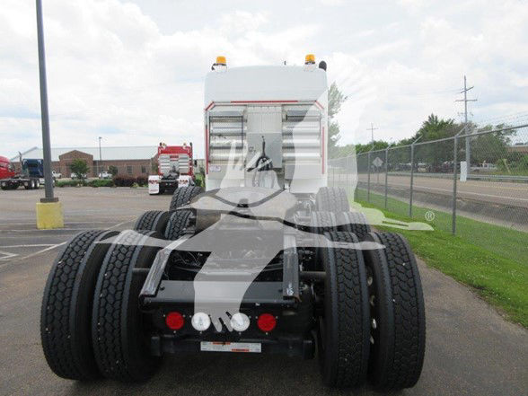 Kenworth W900L rear view showing fifth wheel, dual rear axles, and fifth wheel hitch with dual rear tires. Visible lights and bumper area.