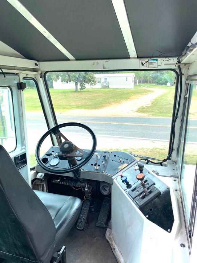 Dashboard of a 2003 Ottawa Commando 50 yard truck showing steering wheel, gauges, and control panel with switches and levers.
