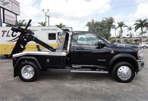 Tow truck side view showing a black 2024 Ram 4500 HD SLT with a Jerr-Dan wheel-lift tow setup.