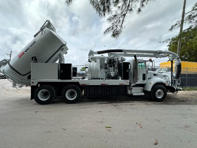 2008 Peterbilt 340 vacuum truck with mounted pump and vacuum tank, white cab and chassis, large rear-mounted vacuum tank, hoses and equipment along the side.