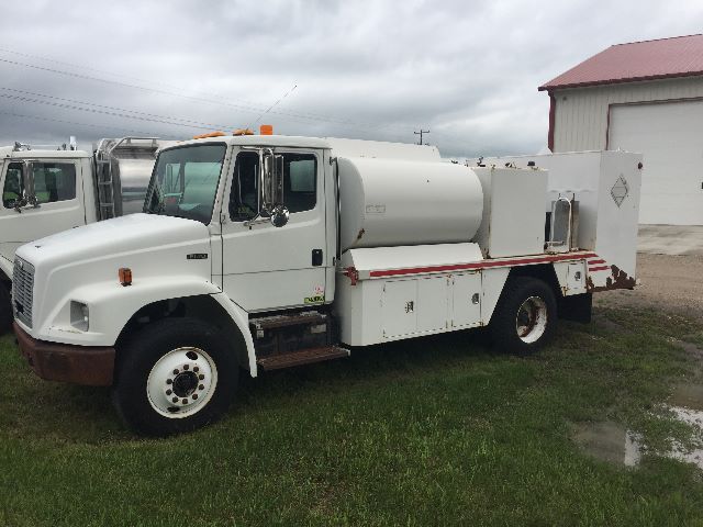 Fuel service truck showing large cylindrical tank, utility compartments, and cab of a 2003 Freightliner FL-70.