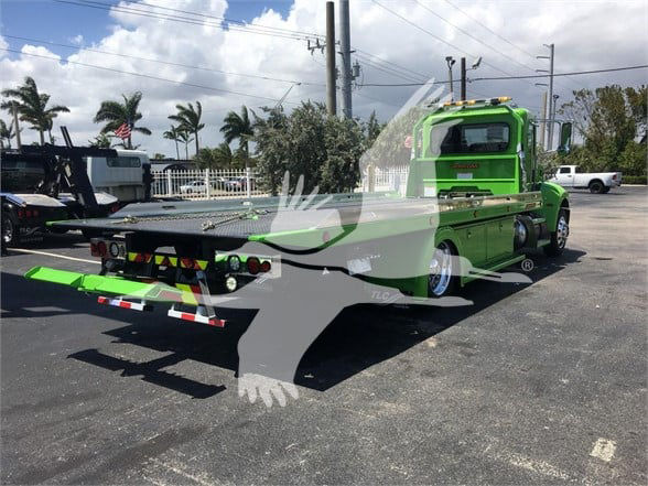 2022 Peterbilt 337 tow truck in bright green with a flatbed, rear view shows flatbed and rear lights.