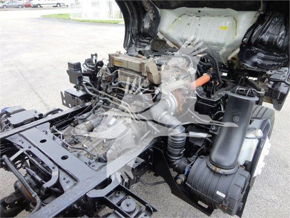 Isuzu NQR engine bay showing intake duct, turbo/intercooler area, and surrounding chassis components.