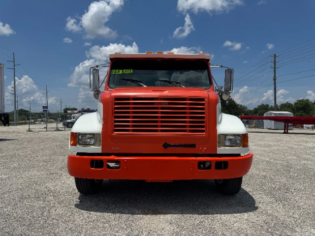 Front view of a red and white 1999 International 4700 DT 466E truck.