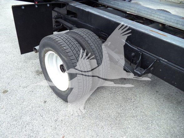 Ford E450 dump truck rear dual wheel area showing rear axle, tires, and chassis frame