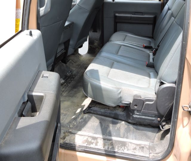 Truck interior showing rear seat and floor area with gray fabric seats and black rubber floor mat. Door panel and step area visible.