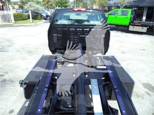 Truck bed with a hitch platform and a rear view showing a GVW label or manufacturer text on the equipment. Visible components include metal rails and a loading platform.