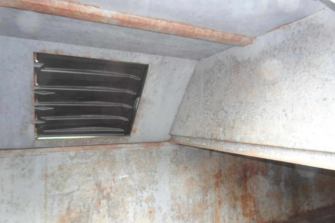Interior of a Wastequip 20 yard dumpster hopper showing a rust-streaked metal interior and a ventilation vent on the side.