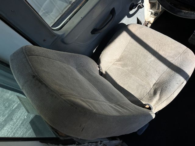 Cab seat in a Kalmar Ottawa yard truck showing fabric seat and part of door frame.