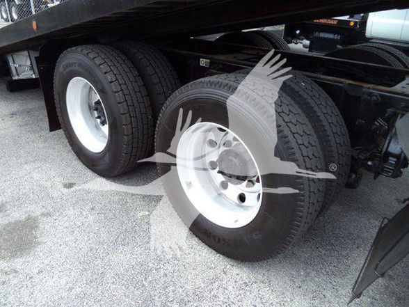 Peterbilt 348 wheel area showing dual rear wheels with white rims and black tires under trailer frame.