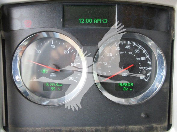 Kenworth W900B instrument cluster showing dual round gauges and digital display with 12:00 AM time reading.