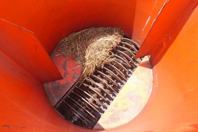 Agri-Metal CA8064 interior with rotating drum and hay entering feed from top, orange hopper walls visible.