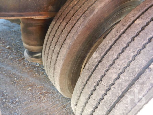 Trailer wheel(s) close-up with dual tires and suspension component visible.