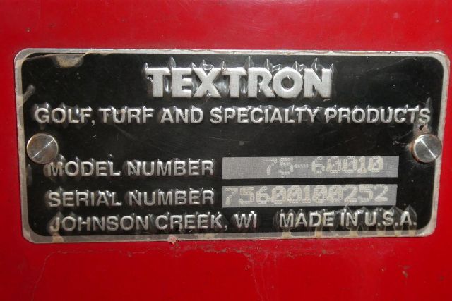 Textron model plate on red equipment showing TEXTTRON Golf, Turf and Specialty Products, Model Number 75-60D10? (blurred), Serial Number 75600100252, Johnson Creek WI Made in U.S.A.