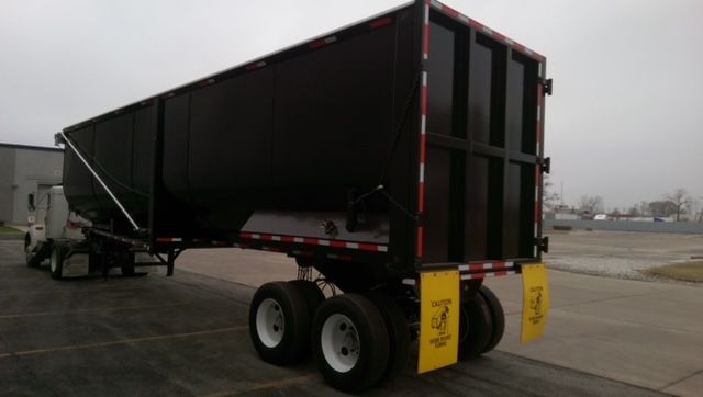 Great Dane dump trailer in yard showing 40 ft round bottom with dual axles and rear gate.
