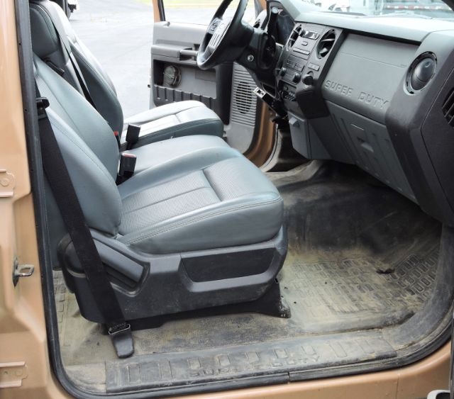 Ford F-350 Crew Cab interior showing front seats and dashboard, grey cloth seats, steering wheel, and rubber floor mats.