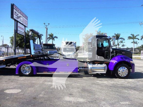 Peterbilt 337 semi-tractor truck in black and purple with a tow bed trailer attached, side view showing chrome fuel tanks and wheels.