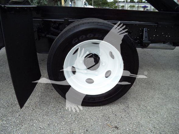 Wheel and tire of a 2017 Chevrolet W4500 dump truck chassis showing white steel wheel and Goodyear tire.