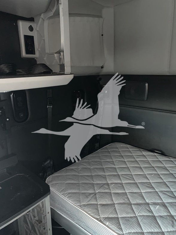 Kenworth T680 interior sleeper cab showing dash, window, and quilted seat cover.