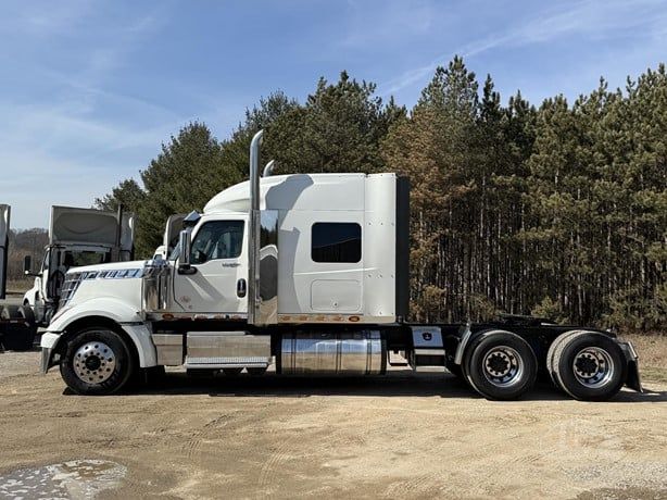International Lonestar tractor-trailer cab in profile view showing sleeper cab, exhaust stacks, chrome fuel tanks, and dual rear axles.
