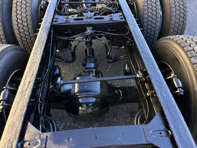 Rear view of Freightliner M2 chassis showing drive axle and dual rear wheels with suspension and driveline components visible.