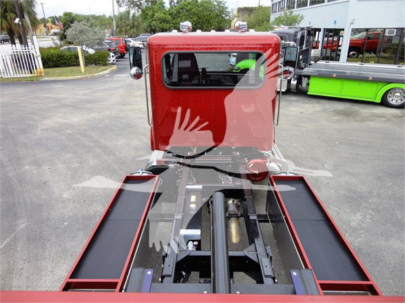Peterbilt 337 truck cab and chassis viewed from rear, showing black frame rails and hydraulic hitch area between bed rails.