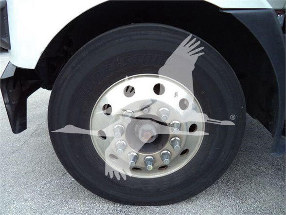 Wheel and tire of a 2023 Mack MD7 truck showing front hub with lug nuts and tire branding.