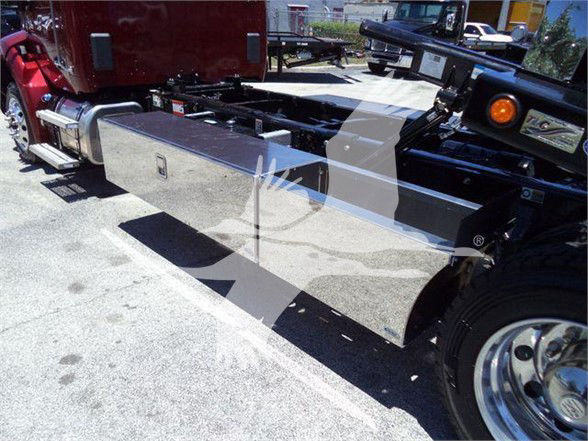 Kenworth T280 truck chassis with large rectangular tool/storage box mounted along the side, view of the fuel/tow configuration, front wheel and frame rails visible.