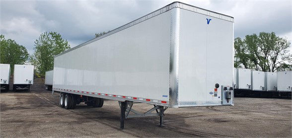 Trailer showing Vanguard MAXCUBE dry van with white aluminum sides and blue V logo, front view on a yard.