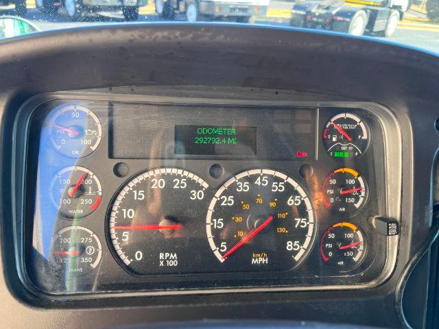 Dashboard of a Freightliner M2 106 showing gauges and an odometer reading 292,792.4 miles, with RPM and speedometer dials visible.