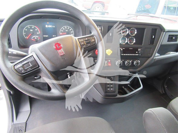 Kenworth T480 truck interior showing steering wheel and dashboard with gauges and controls.