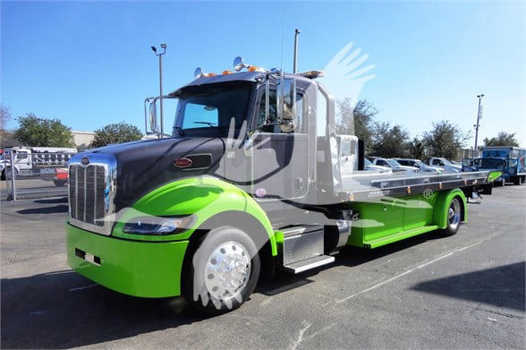 Tow truck with lime green and gray color scheme, Peterbilt logo on grille, side mirrors, chrome wheels; image shows the front and side profile of a tow truck.