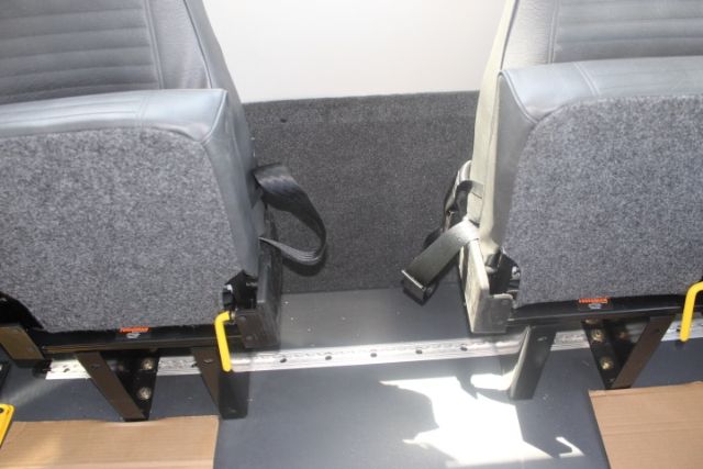 Ford E-450 shuttle bus interior with seating and aisle floor rails.