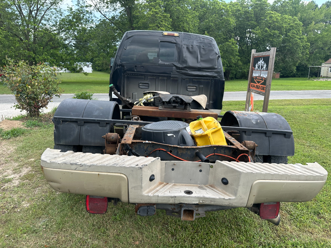 Ford F-450 King Ranch chassis cab rear view with bed removed, showing dual rear wheels, fuel container, wiring, and hitch.