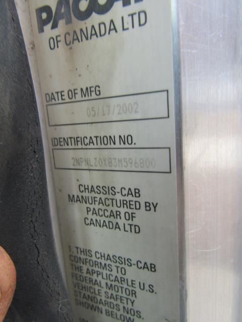 Vertical metal plate with manufacturer info: 'PACCAR OF CANADA LTD' and identification number '2NPFLZ0X83MS696800' visible; date of manufacture box shows '05/17/2002'; text about chassis-cab manufactured by Paccar of Canada Ltd.
