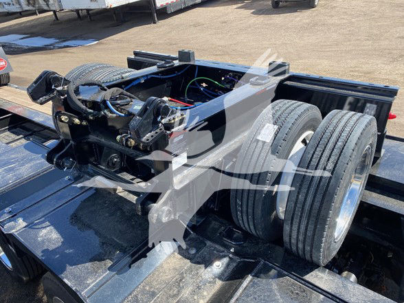 Trailer chassis with dual rear axles and Kingpin coupling area, visible tires and hydraulic components on a Load King lowboy trailer.