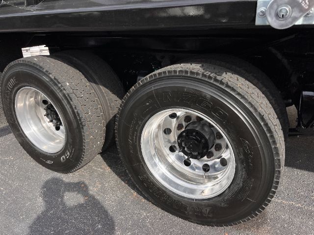 Dual rear wheels with M-... brand tire, rims on a Freightliner truck, tire sidewalls showing ZENESIS or FUI? The image shows wheel assemblies; text on tires and rims not fully legible.