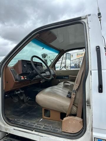 Truck cab interior of a 1991 Chevrolet Kodiak showing steering wheel, dashboard, and beige seat.